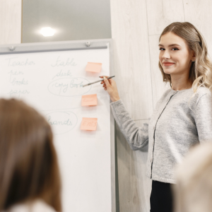 Teacher standing at whiteboard in a classroom